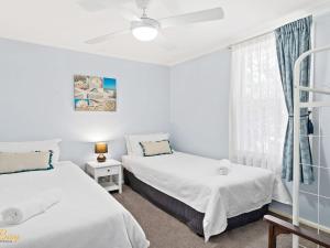 sypialnia z 2 łóżkami i oknem w obiekcie Lentara Street No 31 w mieście Fingal Bay