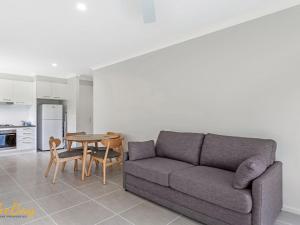 una sala de estar con un sofá y una mesa en Scott Street Couples Getaway, en Anna Bay