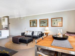a living room with a table and a couch at Bay Village No 7 Shoal Bay in Shoal Bay