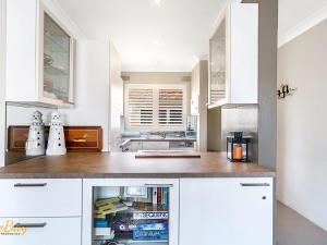 a kitchen with white cabinets and a counter top at Bay Village No.7 Shoal Bay in Shoal Bay