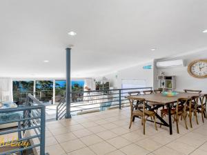 a dining room with a table and chairs and a clock at Water Views on Wallawa in Nelson Bay