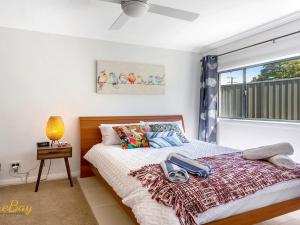 a bedroom with a bed and a window at Karinya at Little Beach Downstairs in Nelson Bay
