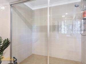 a shower with a glass door in a bathroom at Karinya at Little Beach Downstairs in Nelson Bay