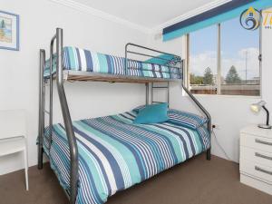 2 łóżka piętrowe w pokoju z oknem w obiekcie Shoal Towers No 9 w mieście Shoal Bay