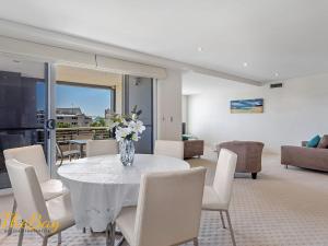 uma sala de jantar com um vaso de flores sobre uma mesa em Carrington No 4 Nelson Bay CBD em Nelson Bay