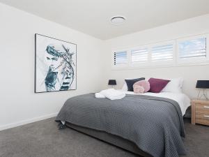 フィンガル・ベイにあるForever Fingal 205 Rocky Pointのベッドと壁に絵が飾られた寝室