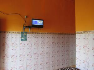Losmen Kinasih Puncak & Gazebo Pandang في بانتول: حمام به تلفزيون على الحائط وجدار