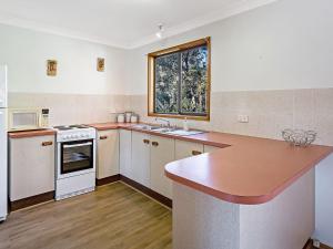 a kitchen with white appliances and a counter top at Catalina 12 Holiday House - Walk to Beaches in Nelson Bay