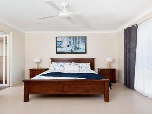 um quarto com uma cama e uma ventoinha de tecto em Little Beach Beauty 38A Achilles Street em Nelson Bay