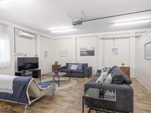 a living room with two couches and a tv at Little Beach Beauty 38A Achilles Street in Nelson Bay