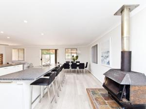 an open kitchen and living room with a stove at Fingal Escape 28 Bent St in Fingal Bay +13 photos