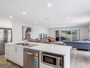 a kitchen with a sink and a living room at Pacific Paradise No 28 Anna Bay in Anna Bay