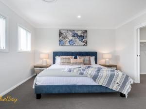 a bedroom with a blue bed and two lamps at Pacific Paradise No 28 Anna Bay in Anna Bay