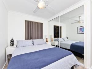 a bedroom with two beds and a mirror at Fingal Escape 28 Bent St in Fingal Bay