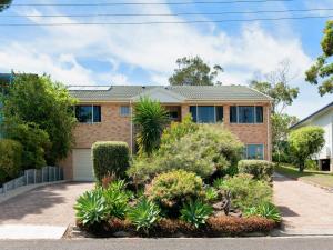 a house with a lot of plants in front of it at Fingal Escape 28 Bent St in Fingal Bay