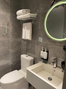 a bathroom with a toilet and a sink and a mirror at Aerotel Beijing Daxing International Airport in Beijing