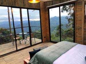 a bedroom with a bed and a view of the mountains at Latibule Glamping in La Vega