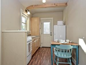 a kitchen with a refrigerator and a table and chairs at Cabins at Flite Acres- Coyote Cabin in Wimberley