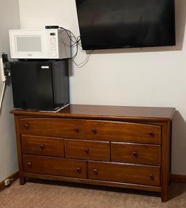 a microwave on top of a dresser with a tv on top at Royal Motel in Ironwood