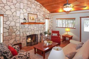 a living room with a stone wall with a fireplace at Burnett Ranch Cabins- Rosemary in Wimberley