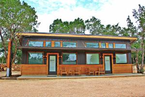 a small wooden house with a lot of windows at Green Acres Cottages - Blanco Suite in Wimberley