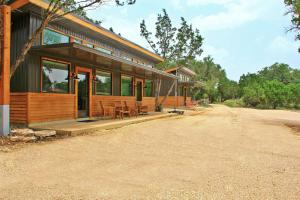 a wooden house with tables and chairs on a road at Green Acres Cottages - Blanco Suite in Wimberley