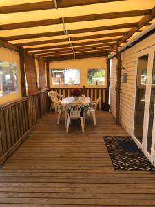 a wooden deck with a table and chairs on it at Mobilhome 2 Chambres 2 SDB in Canet-en-Roussillon