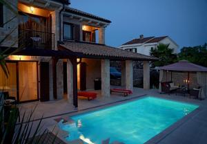 uma casa com piscina em frente a uma casa em Villa Berna - pool house em Malinska