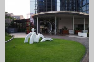 a sculpture on the grass in front of a building at Simple and luxury one bedroom apartment lavenue by sang living in Jakarta