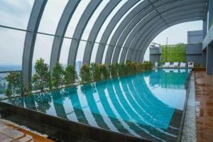a swimming pool on top of a building at Simple and luxury one bedroom apartment lavenue by sang living in Jakarta