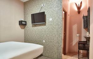 1 dormitorio con 1 cama y TV en la pared en Twins Hotel, en Yakarta