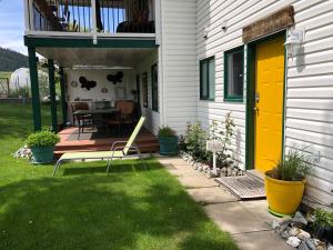 a house with a yellow door and a patio at Country Cottage B&B in Vernon