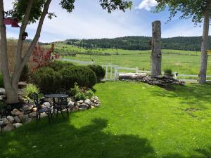 a garden with a table and chairs in the grass at Country Cottage B&B in Vernon