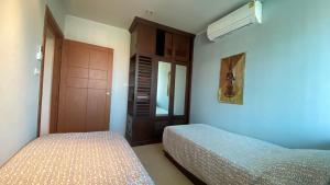 a bedroom with two beds and a closet at Seaview Beachfront Maephim Beach A12 A13 in Rayong