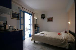 1 dormitorio con 1 cama y cocina con ventana en Sunny Beach Studios, en Naxos Chora