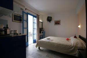 a bedroom with a bed and a kitchen with a window at Sunny Beach Studios in Naxos Chora