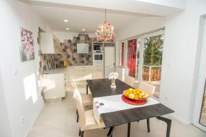 a kitchen and dining room with a table and chairs at IDIS Holiday Home in Omiš