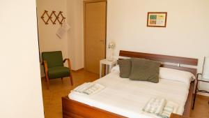 um quarto com uma cama e uma cadeira verde em L'Arcadia em Giffoni Sei Casali