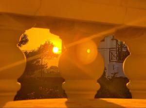 un coucher de soleil vu à travers une arche d'un bâtiment dans l'établissement Anna's Apartment and Studio, à Artemi