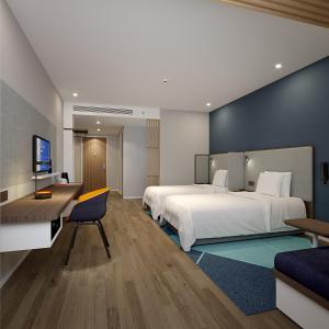 重慶市にあるHoliday Inn Express Chongqing Airport Zone, an IHG Hotelのベッド2台とデスクが備わるホテルルームです。