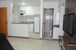een keuken met een wastafel, een toilet en een televisie bij Thermas Paradise 2Quartos in Rio Quente