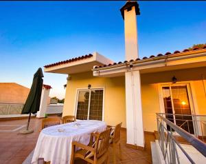 Una mesa y sillas en un balcón de una casa. en Anna's Apartment and Studio, en Artemida