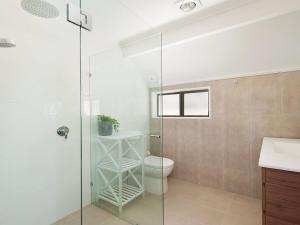 Un baño con inodoro y ducha de cristal. en Kingsley Beach House Boat Harbour, en Anna Bay 13 fotos más