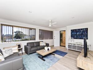 a living room with a couch and a table at Fingal Escape 28 Bent St in Fingal Bay