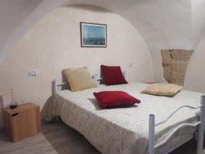 a bedroom with a bed with two red pillows on it at La Fontana in Gallipoli