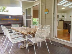 a dining room with a wooden table and white chairs at Riverside Retreat 544 Ocean Drive North Haven in North Haven