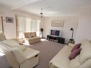 a living room with two white couches and a tv at Holiday Haven at North Haven in North Haven