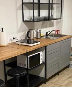 a kitchen counter with a sink and a microwave at TamTam Urban in Cluj-Napoca