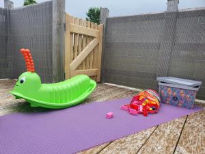 un tapete de juegos para niños con un juguete verde inflable en Le Fiege gîte cosy et confort, en Torchamp