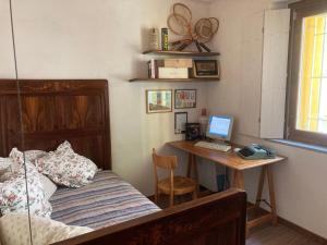 a bedroom with a bed and a desk with a computer at CasaGialla in Marone